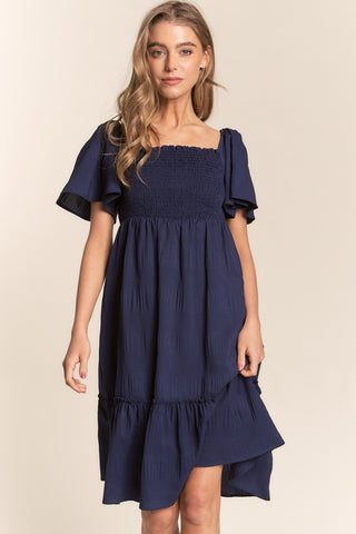Shop J.NNA Smocked Bow Back Ruffle Hem Dress Now On Klozey Store - Trendy U.S. Premium Women Apparel & Accessories And Be Up-To-Fashion!